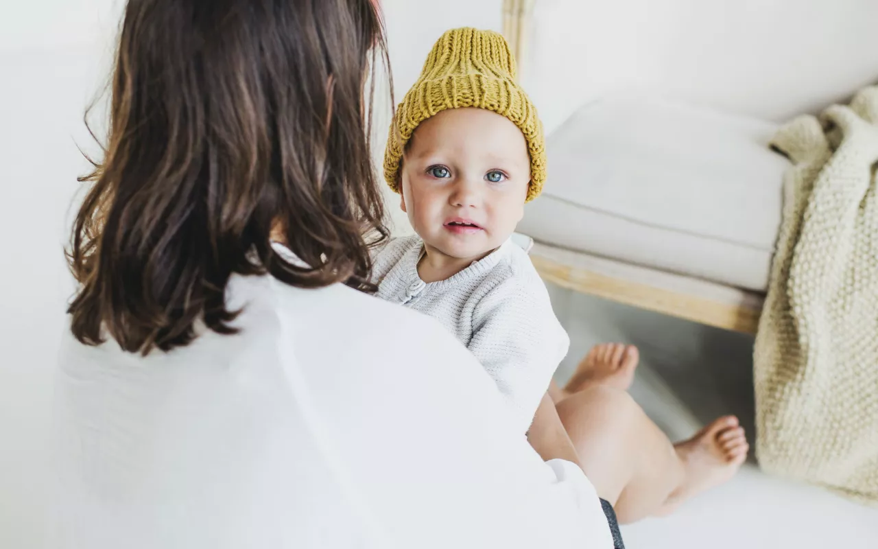 Eine Frau hält ein Baby auf dem Arm. 