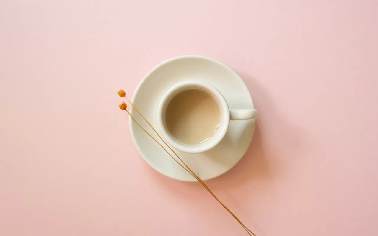 Eine Kaffeetasse auf rosafarbenem Hintergrund. 