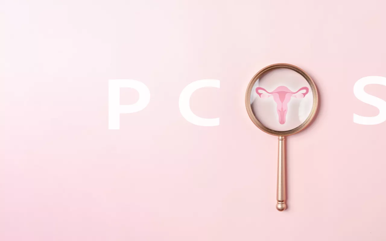 Der Schriftzug PCOS und eine Lupe