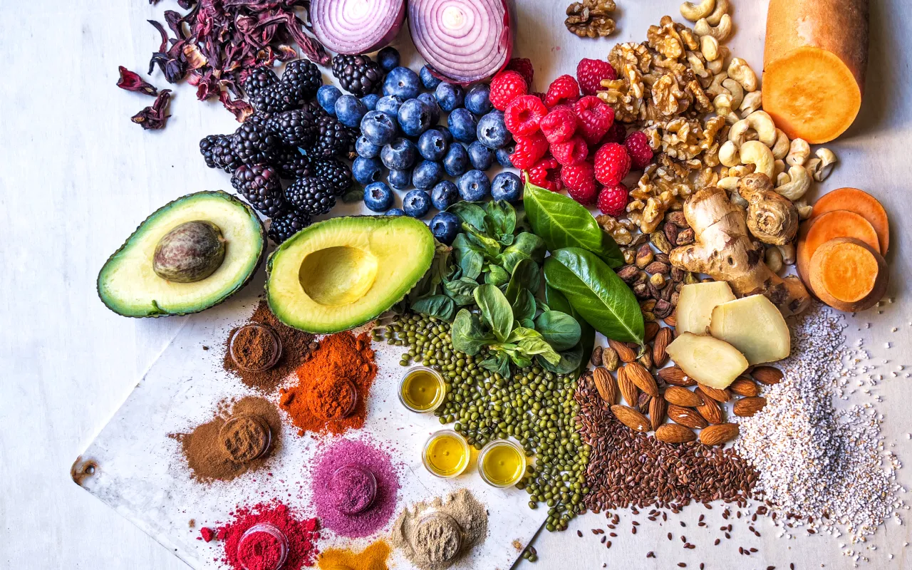 Buntes Gemüse, Obst, Hülsenfrüchte, Nüsse und Gewürze auf Holztisch