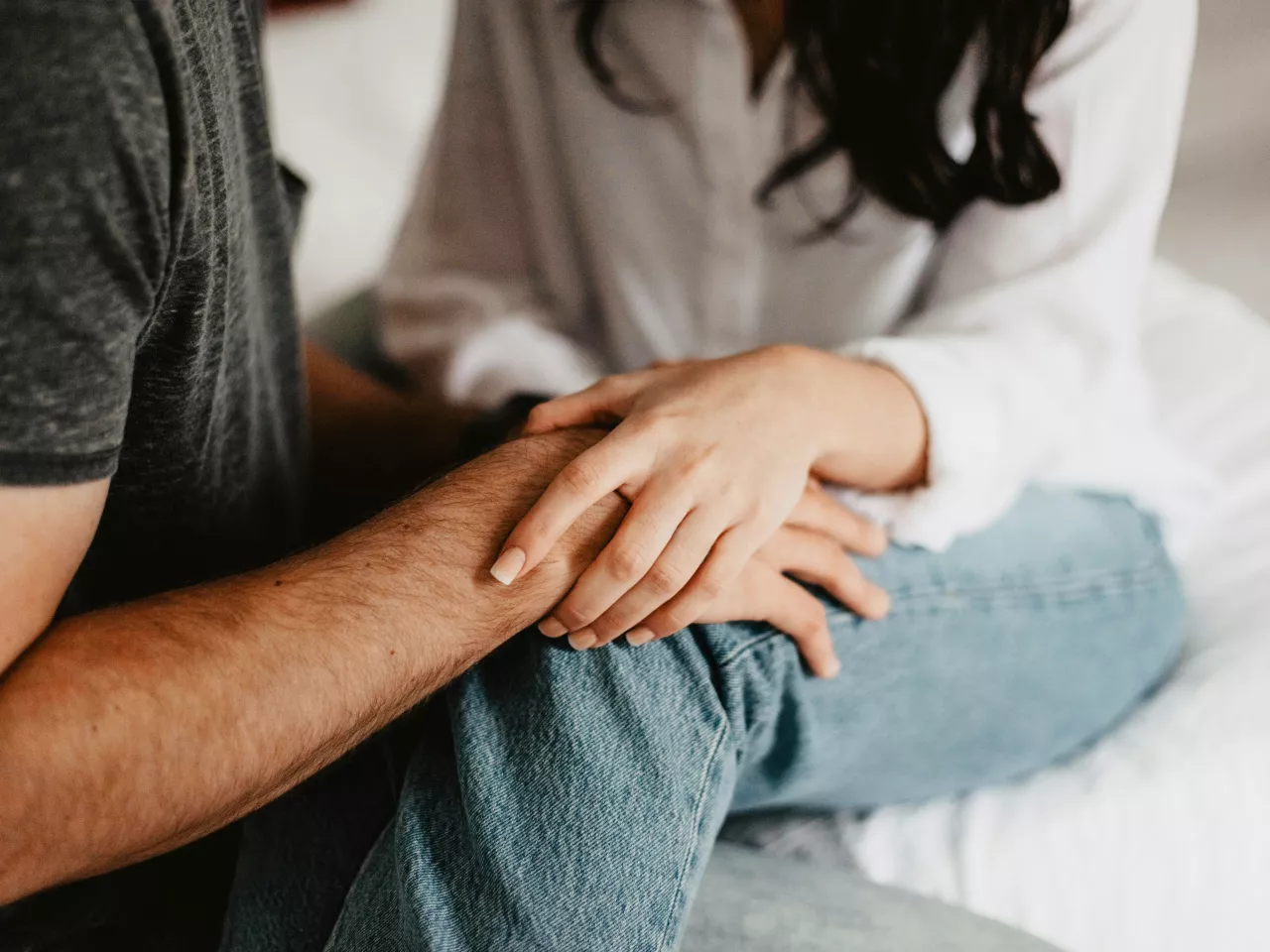 Ein Paar mit Kinderwunsch hält sich an den Händen. 