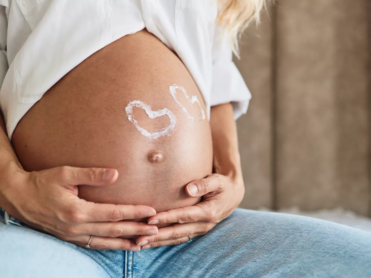 Frau die sich mit beiden Händen den Babybauch hält
